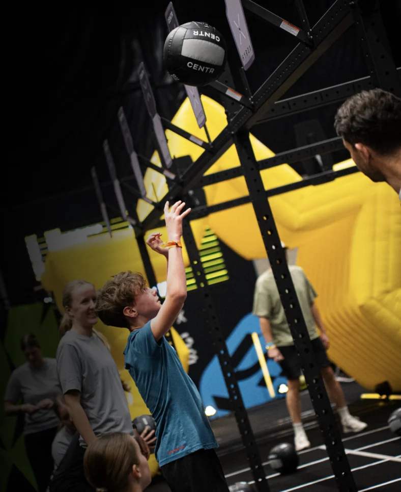 kid does a wall ball exercise in a Hyrox race